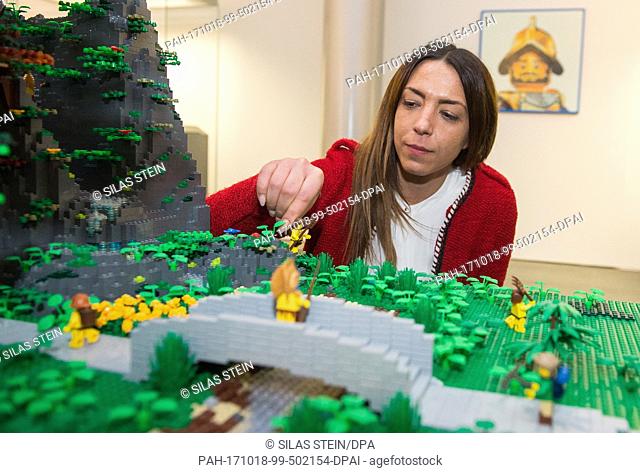 A woman placing a lego figure in the lego world ""South America"" as part of a special exhibition called ""cities-castles-pyramids"" is showing, a.o