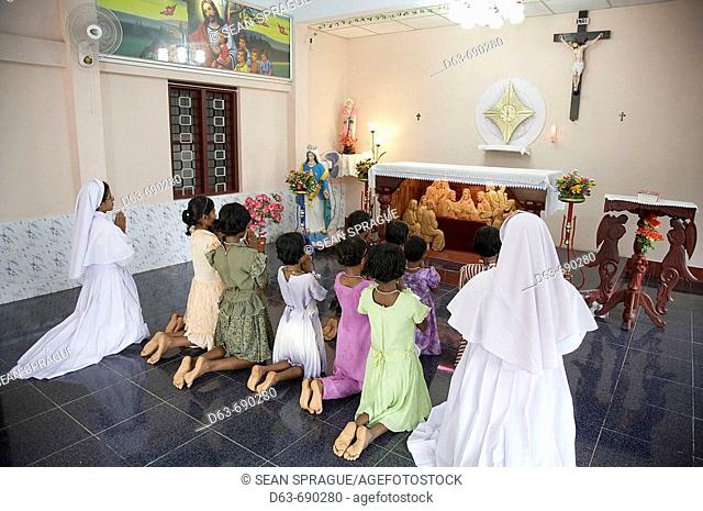 Nuns and girls at prayer. Mary Matha Bala Bhavan, a girls' orphanage run by Syro-Malabar Catholic Missionary Sisters of Mary Immaculate (MSMI), Chamal village