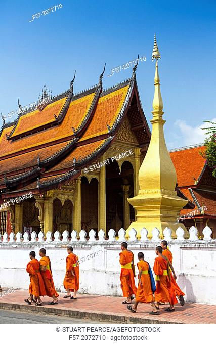 Young novice monks walk past Wat Sop in Luang Prabang, Laos