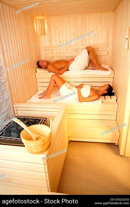 Man and woman lying in sauna, relaxing on wellness