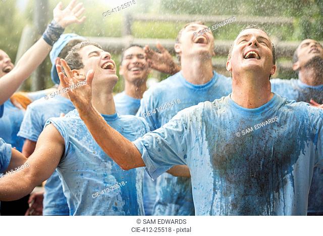 Enthusiastic team enjoying rain at boot camp