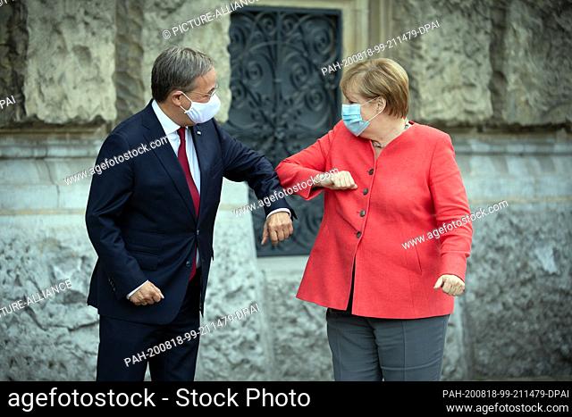 18 August 2020, North Rhine-Westphalia, Duesseldorf: Chancellor Angela Merkel (CDU) is welcomed by Armin Laschet (CDU), Prime Minister of North Rhine-Westphalia