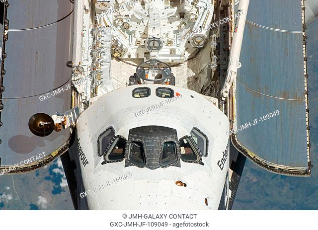 An overhead view of the exterior of Space Shuttle Endeavour's crew cabin, part of its payload bay doors, docking system and part of the Dextre robotic system...