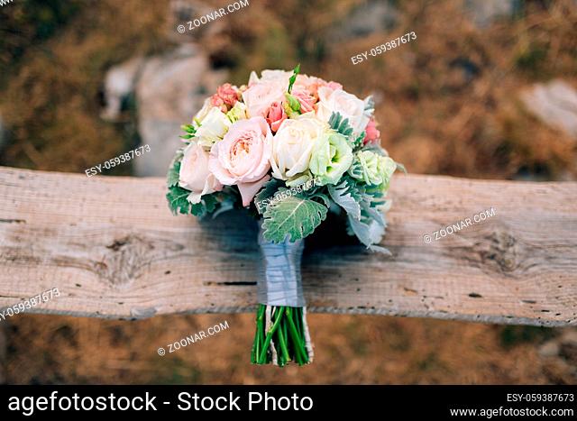 Wedding bridal bouquet of Lisianthus and Cineraria Silver on an old wooden bench handmade. Wedding in Montenegro, Adriatic