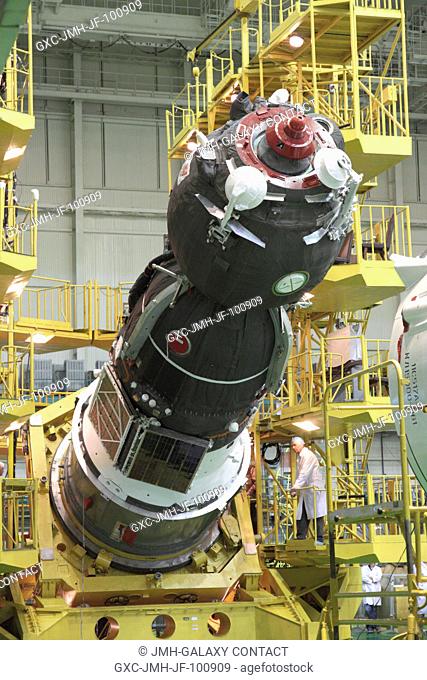 At the Baikonur Cosmodrome in Kazakhstan, the Soyuz TMA-04M spacecraft is rotated to a horizontal position as technicians monitor the operation May 8