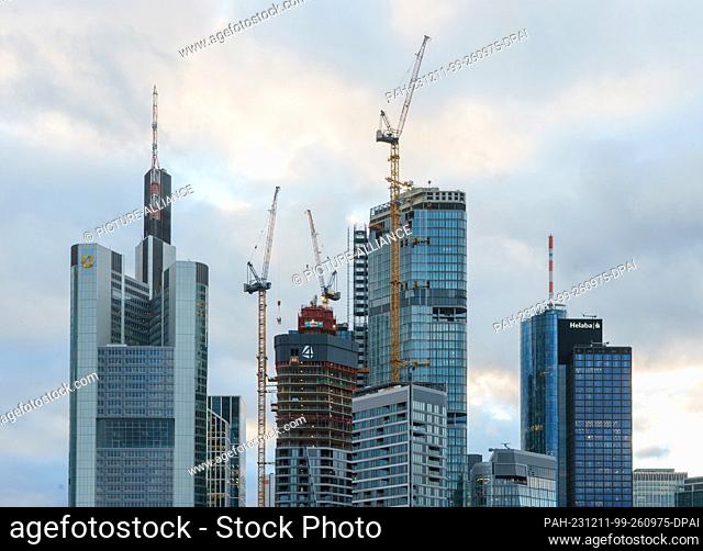 PRODUCTION - 11 December 2023, Hesse, Frankfurt/Main: The four high-rise towers of the ""FOUR"" construction project are framed by the Commerzbank Tower (l) and...