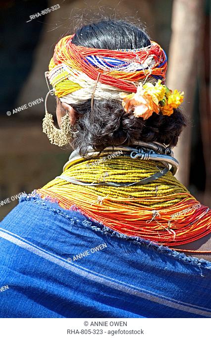 Bonda tribeswoman wearing blue cotton shawl over traditional bead costume, with beaded cap, large earrings and metal necklaces, Rayagader, Orissa, India, Asia