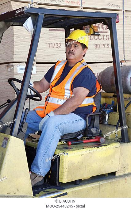 Forklift driver driving in warehouse