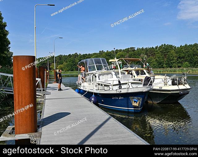 17 August 2022, Brandenburg, Kersdorf: The two boats of Peter Fischer and Matthias Graupner are moored at a jetty on the Spree River in front of the closed...