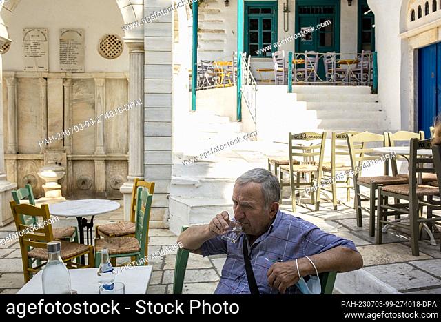 16 June 2023, Greece, Pyrgos: June 16, 2023, Greece, Tinos: sitting in a café in the main square of the village of Pyrgos
