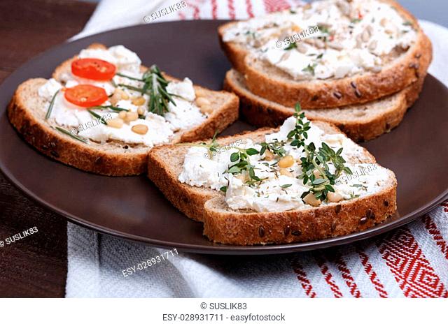 Sandwich with soft cheese and spinach surrounded composition of quail eggs red pepper and walnuts