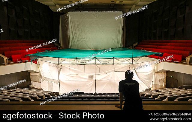 09 June 2020, Saxony, Leipzig: An employee looks at the enclosure of the stage in the Great Hall of the Leipzig Gewandhaus