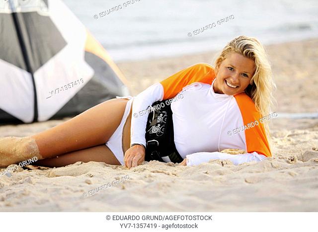 Smiling young blonde woman lying on the beach