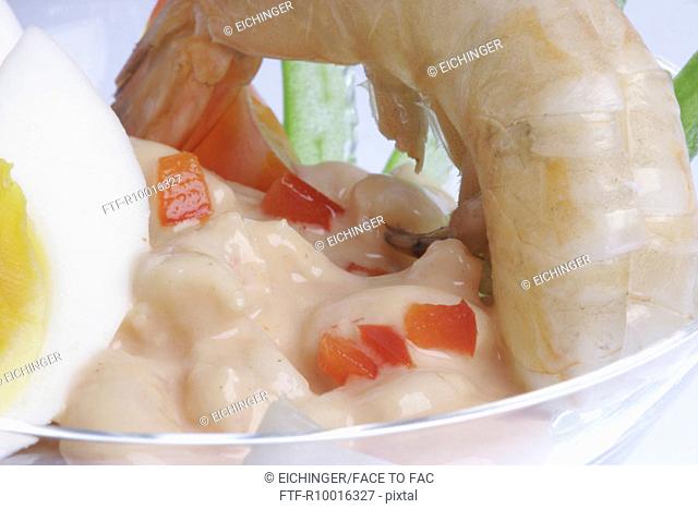 A bowl of lobster, shrimpsalad and eggs garnished with paprika