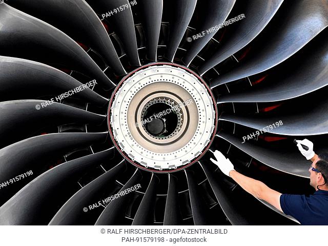 dpatop - A novel airplane engine of the Rolls-Royce Trent XWB type being inspected by an employee in an assembly hall in Dahlewitz, Germany, 12 June 2017