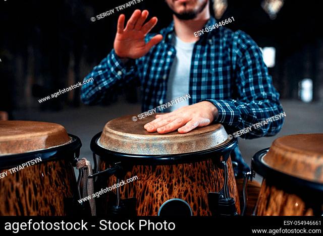 Drummer hands playing on wooden drum, closeup. Bongo, musical percussion instrument, ethnic music