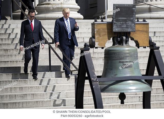 US President Donald J. Trump (R) and Secretary of Treasury Steven Mnuchin (L) walk down the steps of the Treasury Department after a financial services...