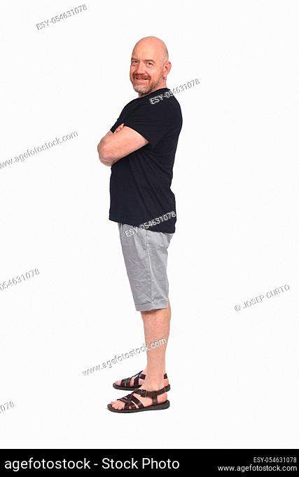 Bald man with sandals t-shirt and shorts, side view arms crossed