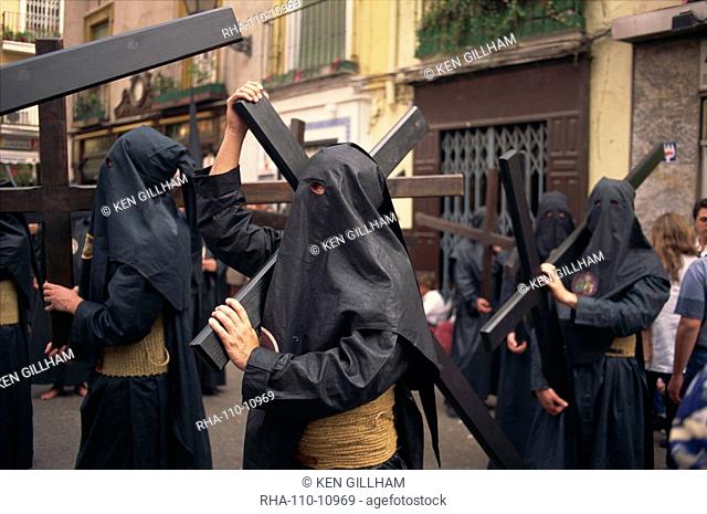 Penitents bearing crosses in procession, Holy Week Semana Santa, Seville, Andalucia, Sapin, Europe
