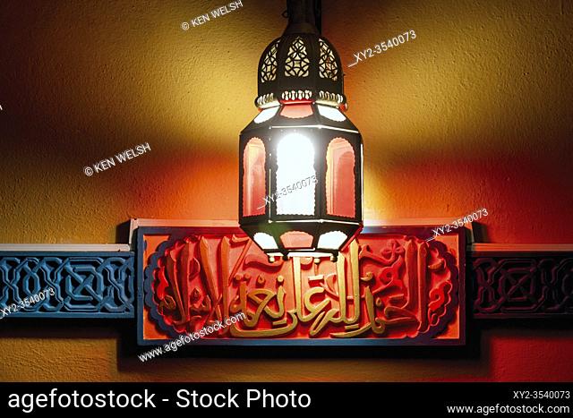 Lamp illuminating Arab script at entrance to cafe. Cordoba, Cordoba Province, Andalusia, southern Spain. The historic centre of Cordoba is a UNESCO World...
