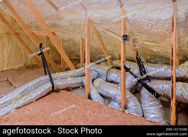 House air ventilation pipes in silver insulation material on the attic with a heating system