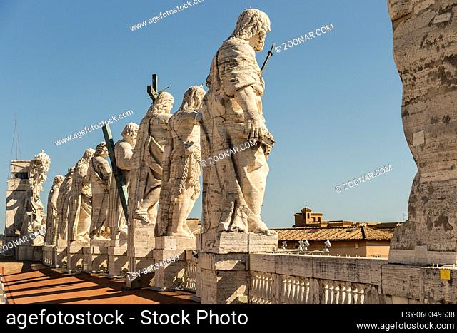 Back view of statues of the saints apostles located on the top of Saint Peter Basilica roof