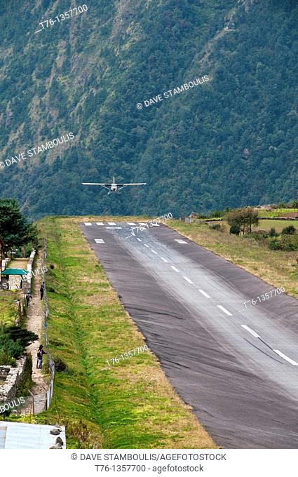 small plane landing on the dangerous and tiny Lukla airstrip in the Everest Region of Nepal