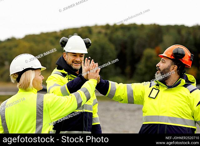 Engineers in reflective clothing high fiving