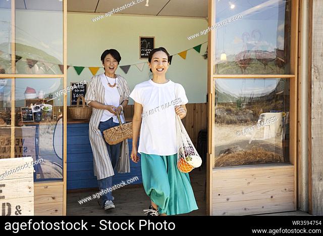 Two smiling Japanese women leaving farm shop