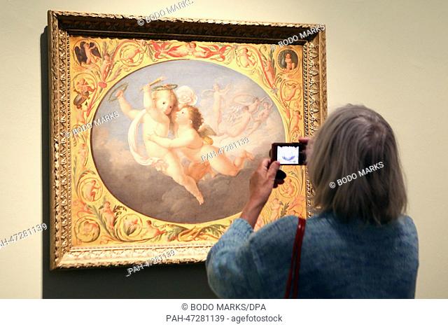 A woman takes a picture of the painting ""Eros and Anteros"" (1803, oil on canvas) by Ferdinand Hartmann (1774 - 1842) in the exhibition ""Transformation of the...