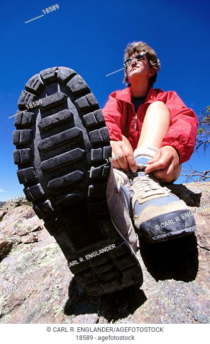 Woman tying shoelaces of boots during hike, Chiricahua National Monument, Arizona, USA