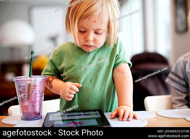 Girl playing with digital tablet