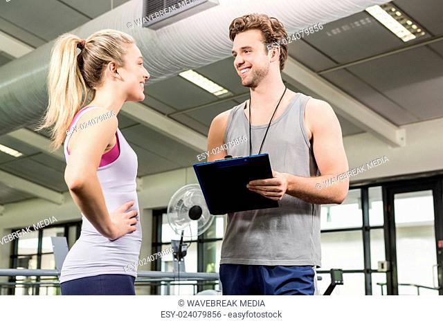 Trainer talking to woman after a workout