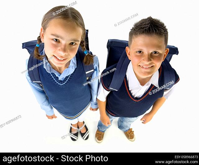 Portrait of boy and girl. They're looking at camera and smiling. Isolated on white in studio, high angle view