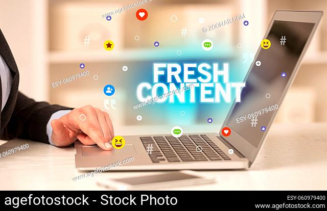 Freelance woman using laptop with FRESH CONTENT inscription, Social media concept