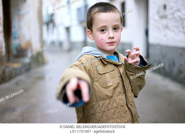 Boy adopting martial art posture on the street, Ludiente, Castellón, Spain