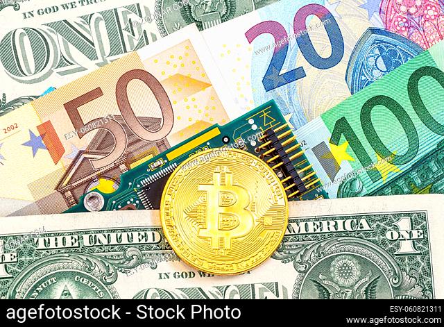 Digital cryptocurrency gold bitcoin lying over electronic computer component and banknotes. Business concept of new virtual money
