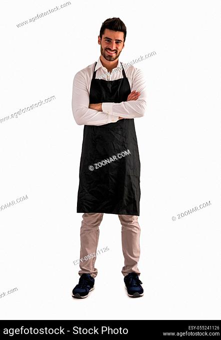 Full length shot of young chef or waiter posing, wearing black apron and white shirt isolated on white background