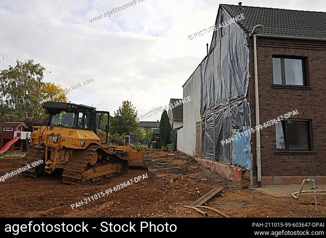 PRODUCTION - 13 October 2021, North Rhine-Westphalia, Erftstadt: An excavator levels earth at the demolition edge in the Blessem district