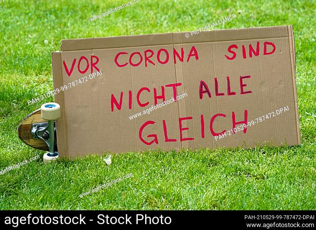29 May 2021, Saxony-Anhalt, Halle: A poster with the inscription ""In front of Corona not everyone is equal"" lies on a meadow during the demonstration of the...