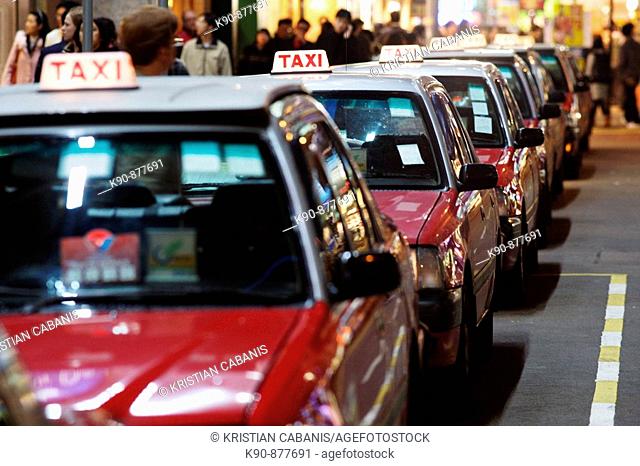 The typical red taxis queueing up idle at a taxi stand in Wanchai (Wan Chai) and waiting for customer, Hong Kong Island, Hong Kong, China, East Asia