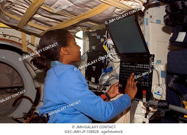 Astronaut Stephanie Wilson, STS-120 mission specialist, uses a computer on the middeck of Space Shuttle Discovery while docked with the International Space...