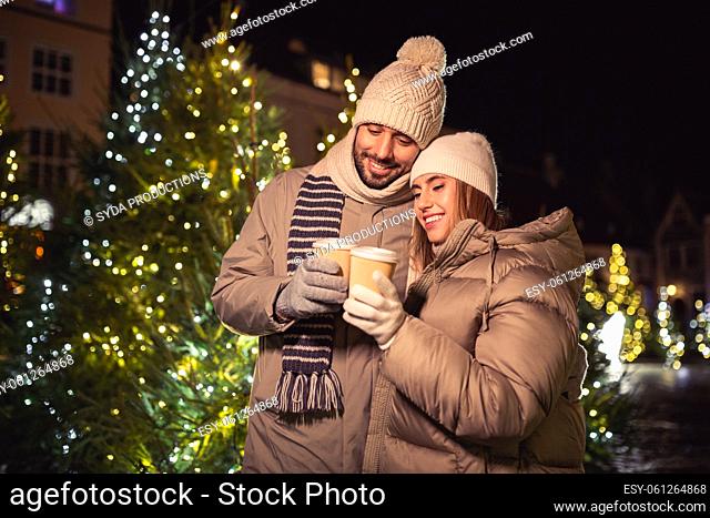 happy young couple with coffee in christmas city