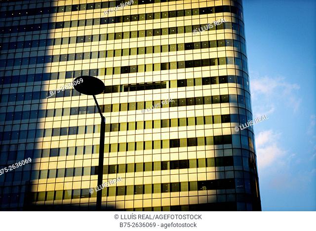 Close-up of an office building with a lamp post silhouette and the blue sky at the sunset. Canary Wharf, Tower Hamlets, East London, England, UK