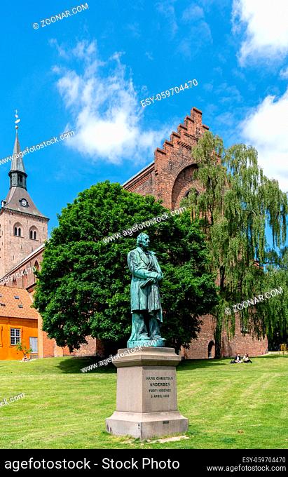 Odense, Denmark - 9 June, 2021: statue of Hans Christian Andersen in the park of Saint Canute Cathedral in downtown Odense