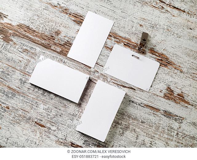 Photo of blank business cards and badge. Photo of blank stationery on wood table background. Flat lay