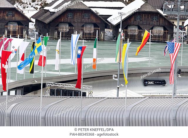 The four-person Bob with Justin Olsen, Austin Landis, Evan Weinstock and Luis Moreira from the USA on the echo-curve lined with flags in Schoenau Am Koenigssee