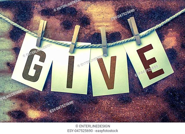 The word GIVE stamped on card stock hanging from old twine and clothes pins over a rusty vintage background