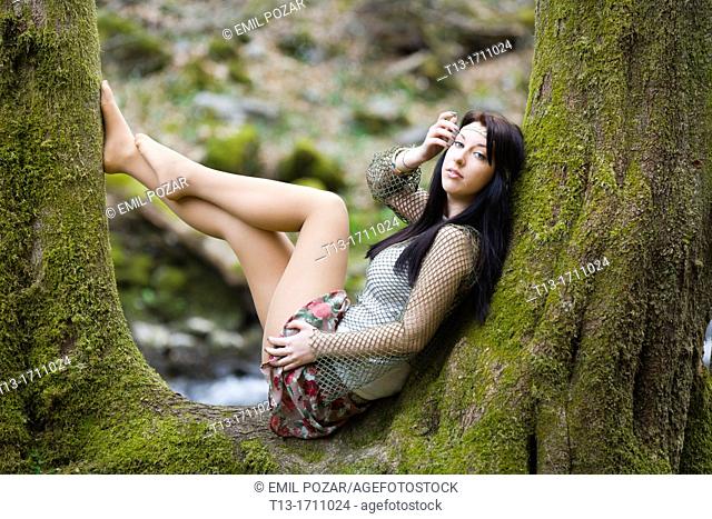 Young teen posing on a tree