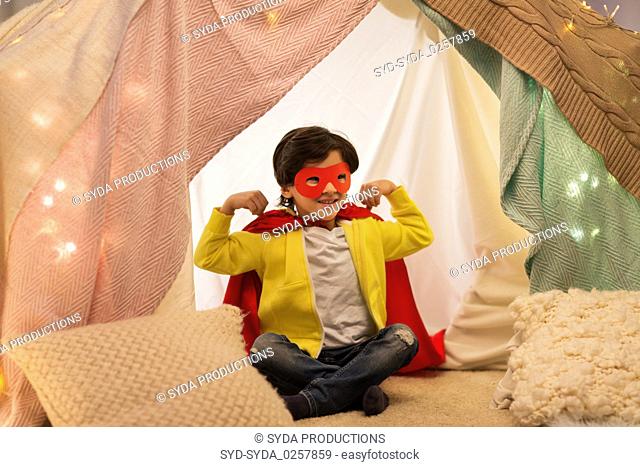 happy boy in super hero stuff in kids tent at home